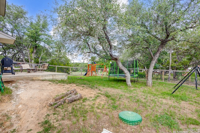 view of yard with a playground and a trampoline