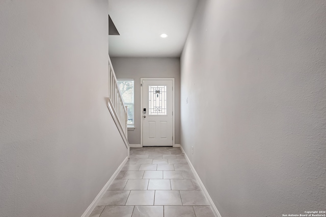 doorway to outside with light tile patterned floors