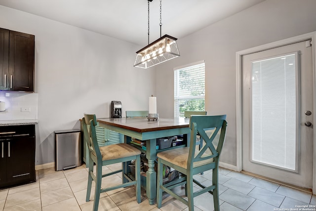 dining area with a notable chandelier and light tile patterned floors