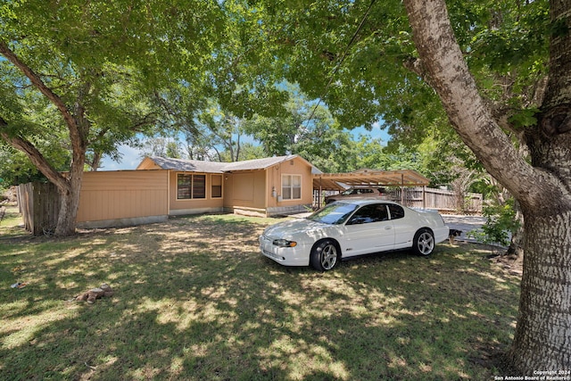 view of front facade featuring a front yard and a carport