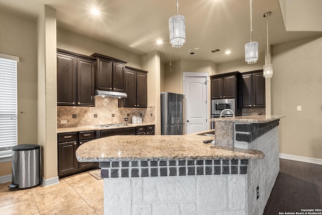 kitchen with appliances with stainless steel finishes, an inviting chandelier, hanging light fixtures, and sink