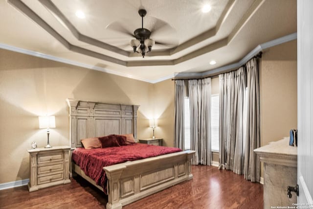 bedroom featuring a tray ceiling, ceiling fan, dark hardwood / wood-style floors, and ornamental molding