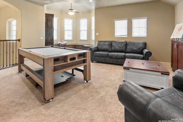 playroom featuring ceiling fan, light colored carpet, a healthy amount of sunlight, and vaulted ceiling