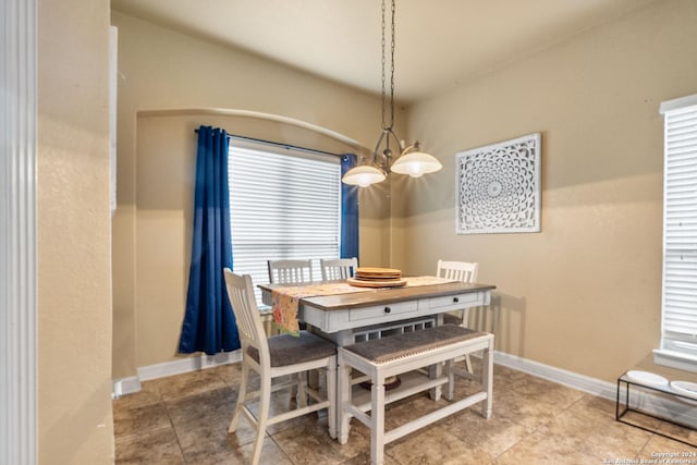 dining area featuring tile patterned floors and a notable chandelier