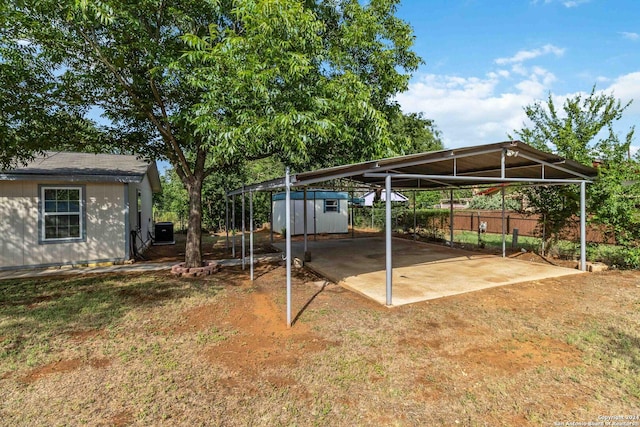 exterior space with central AC unit, a shed, and a carport