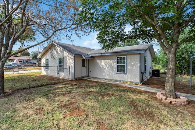 ranch-style house with central air condition unit and a front yard