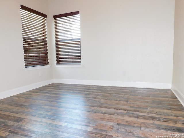 unfurnished room with dark hardwood / wood-style flooring