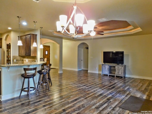 kitchen featuring hanging light fixtures, a tray ceiling, and dark hardwood / wood-style floors