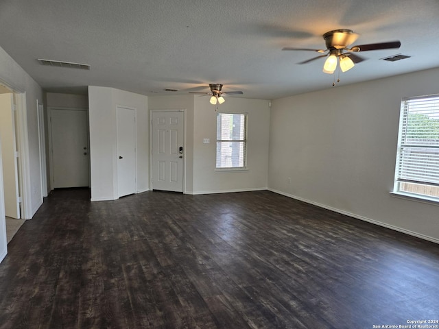 unfurnished living room featuring ceiling fan, a textured ceiling, and dark hardwood / wood-style floors