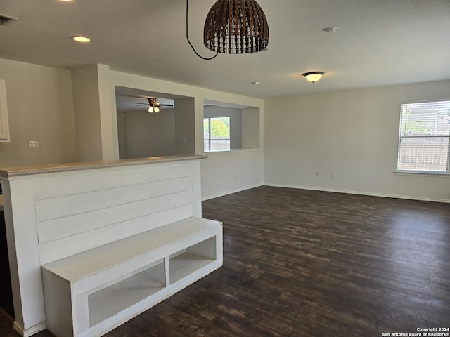 interior space with plenty of natural light, ceiling fan, and dark hardwood / wood-style flooring