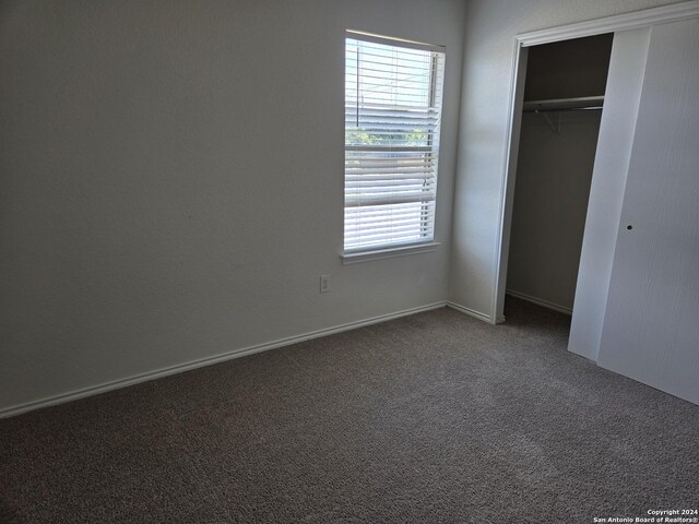 unfurnished bedroom featuring a closet and carpet flooring