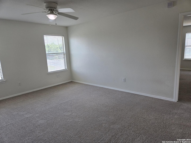 unfurnished room with ceiling fan and carpet