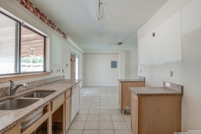 kitchen featuring sink, white dishwasher, a textured ceiling, and light tile patterned floors