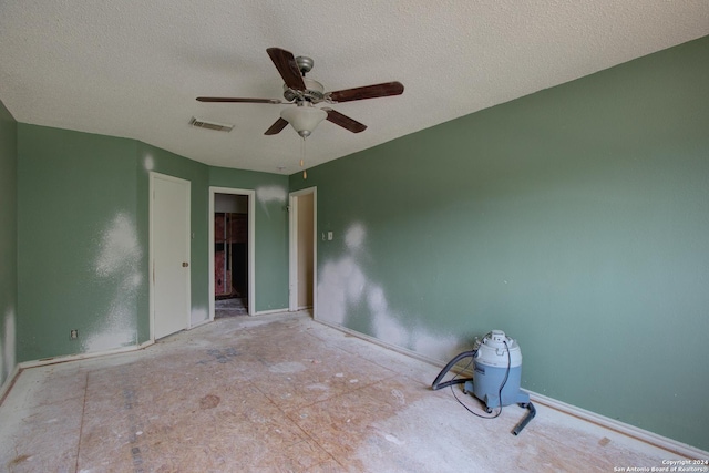 unfurnished room with ceiling fan and a textured ceiling