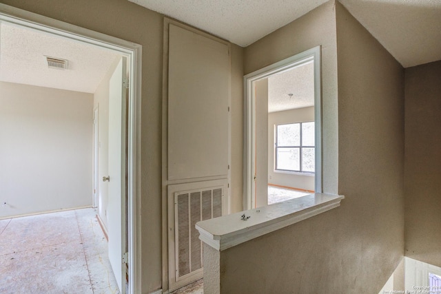 hall featuring a textured ceiling