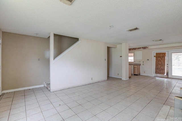 unfurnished living room featuring light tile patterned floors and a textured ceiling