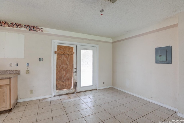 unfurnished room with electric panel, light tile patterned floors, and a textured ceiling