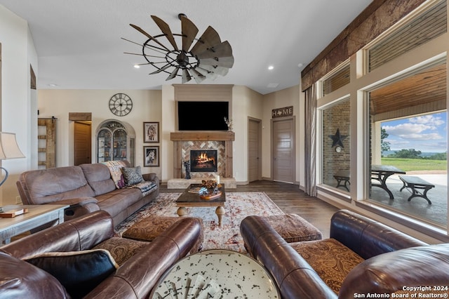 living area with wood finished floors, recessed lighting, a fireplace, and ceiling fan