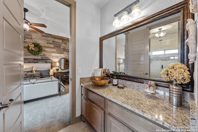 bathroom featuring ceiling fan, wood walls, and vanity