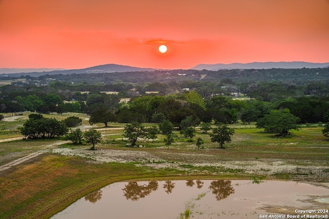 property view of mountains featuring a water view and a wooded view