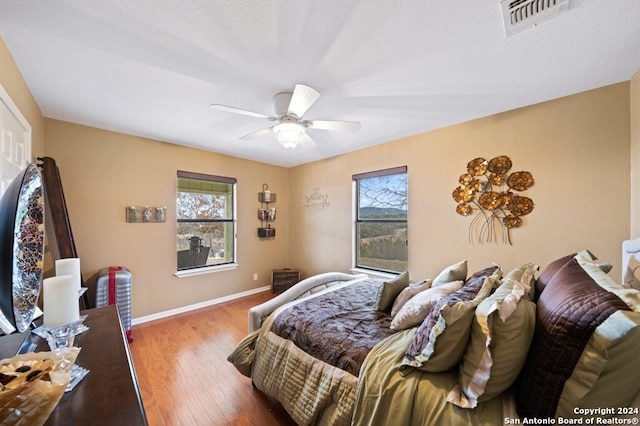 bedroom featuring a textured ceiling, ceiling fan, and wood-type flooring