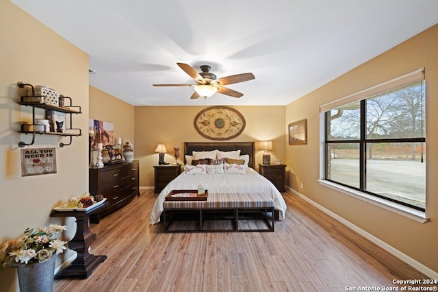 bedroom with baseboards, light wood-type flooring, and a ceiling fan