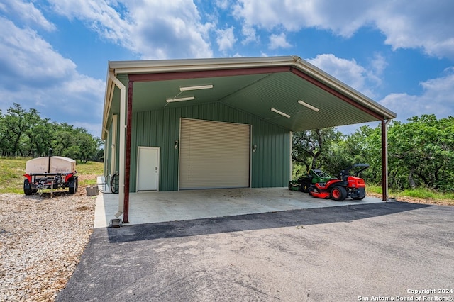 garage with driveway and a detached garage