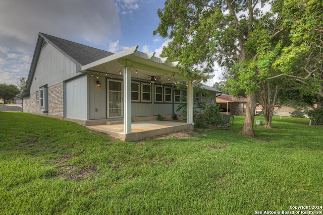 rear view of property featuring a patio area, ceiling fan, and a yard