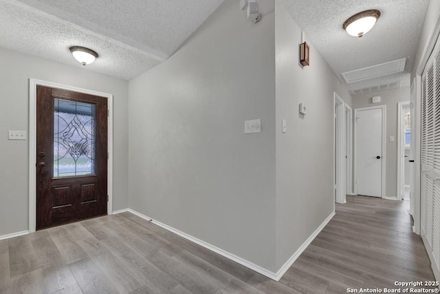 foyer entrance with wood-type flooring and a textured ceiling