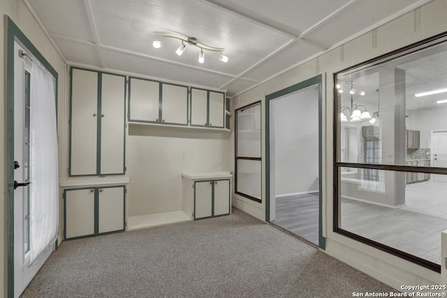 carpeted spare room featuring a notable chandelier