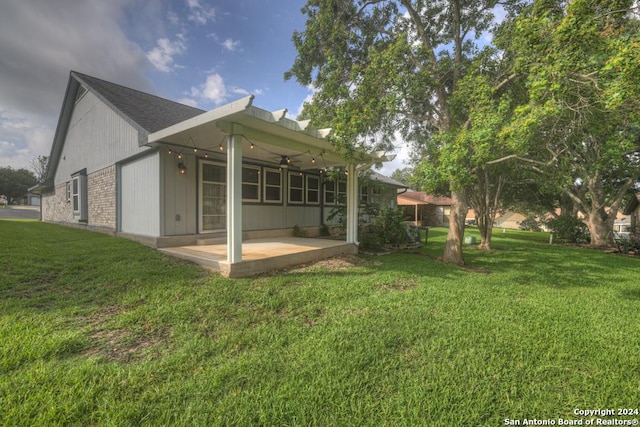 back of property featuring a yard, a patio, and ceiling fan