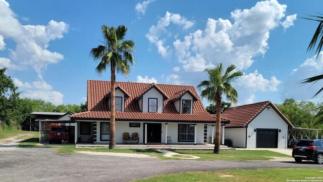 view of front of property with covered porch, a garage, and a carport