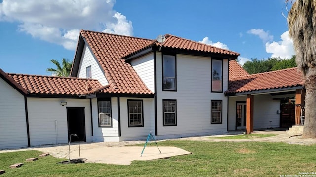 rear view of house featuring a patio and a yard