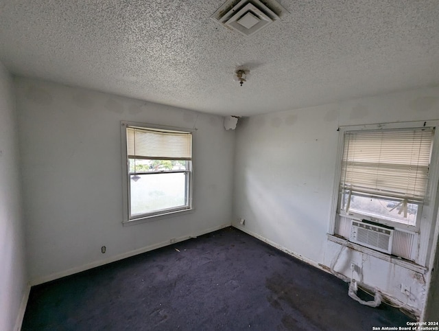 carpeted empty room with cooling unit and a textured ceiling