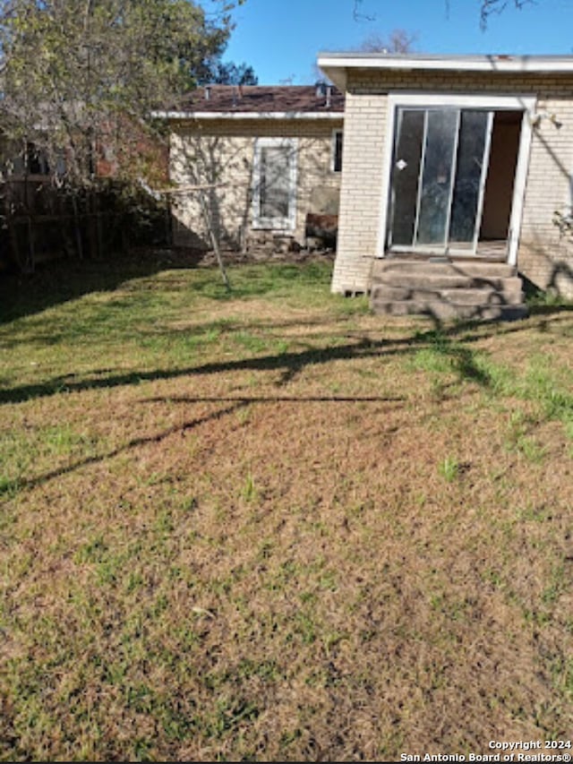 rear view of house featuring a yard