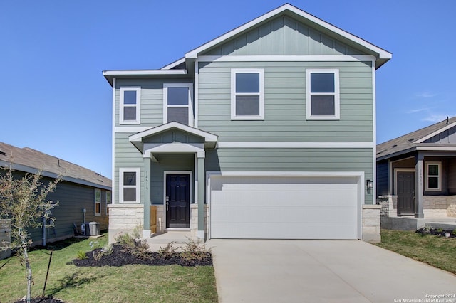 craftsman-style home with central air condition unit, a front lawn, and a garage