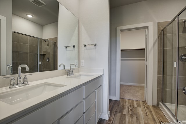 bathroom featuring hardwood / wood-style flooring, walk in shower, and vanity