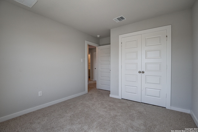 unfurnished bedroom with a closet and light carpet