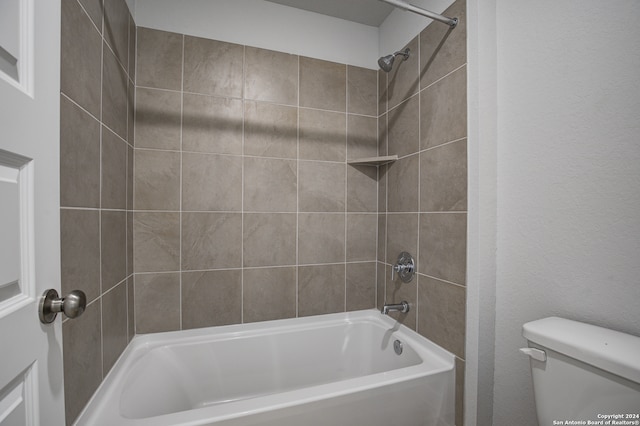 bathroom featuring tiled shower / bath combo and toilet