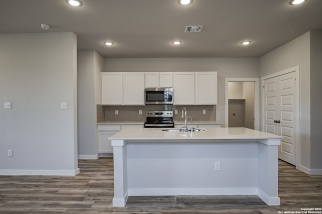 kitchen featuring stainless steel appliances, an island with sink, sink, white cabinetry, and tasteful backsplash