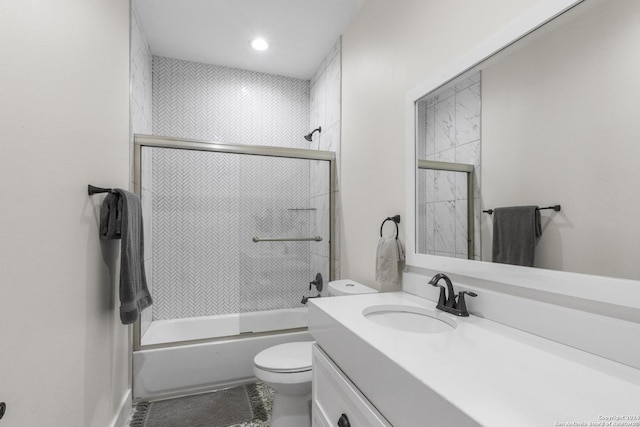 full bathroom with tile patterned flooring, vanity, bath / shower combo with glass door, and toilet