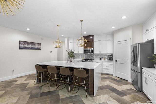 kitchen featuring white cabinets, appliances with stainless steel finishes, and an island with sink