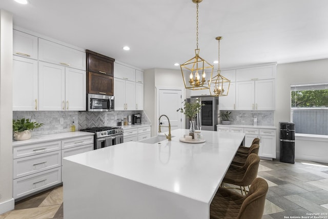 kitchen featuring a center island with sink, white cabinetry, and stainless steel appliances