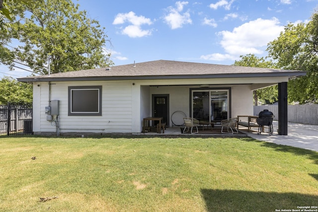 rear view of house featuring a patio area and a yard