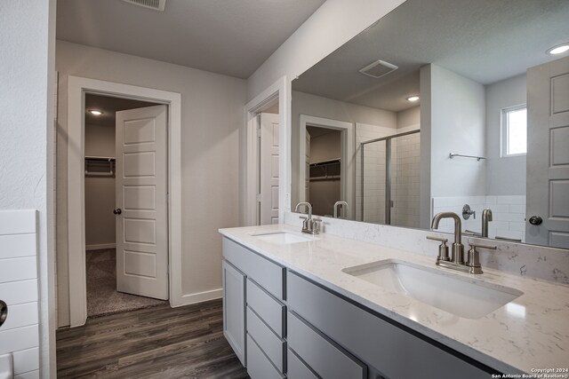 bathroom featuring hardwood / wood-style flooring, vanity, and a shower with shower door