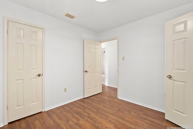 unfurnished bedroom with hardwood / wood-style floors