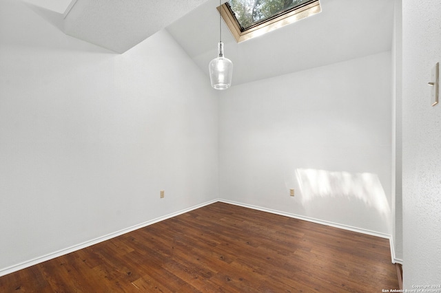 unfurnished room featuring dark wood-type flooring and lofted ceiling with skylight