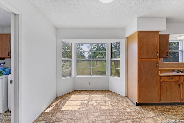 kitchen with washer / clothes dryer, sink, and a textured ceiling