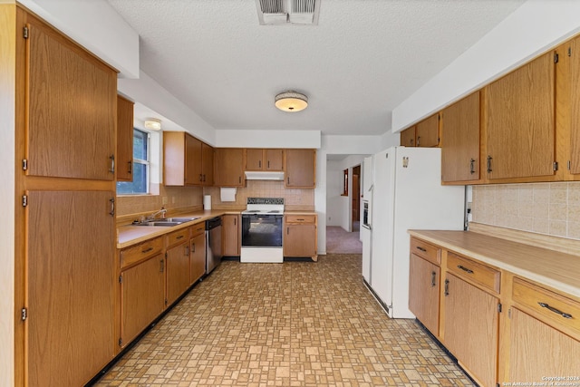 kitchen with decorative backsplash, white appliances, sink, and a textured ceiling