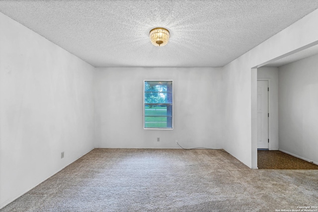 spare room featuring carpet flooring and a textured ceiling